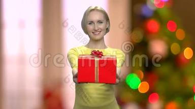 女人在抽象的圣诞节背景上送礼物。