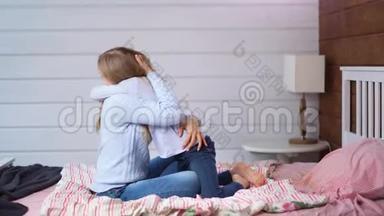 光脚女孩给妈妈一个<strong>大大</strong>的拥抱，她坐在卧室的床上，在家里的室内全射