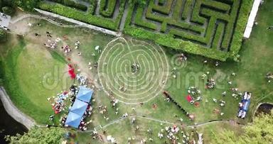 一个由草地上的石头组成的圆形迷宫。 <strong>很多人</strong>，野餐。