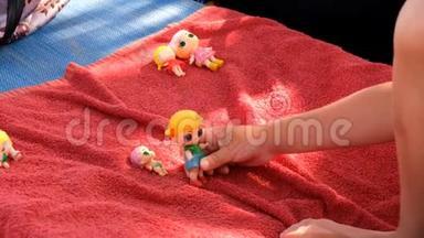 在阳光明媚的一天，<strong>可爱</strong>的女孩在沙滩上的日光浴床上玩她的<strong>娃娃</strong>。