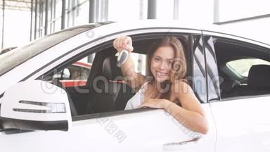 幸福的女司机在<strong>车展</strong>室的新车里拿着车钥匙