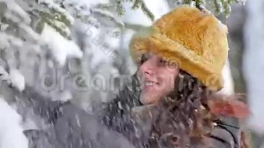 微笑的冬天少年站在松树下，雪落在她身上