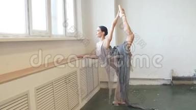 芭蕾舞者向后弯曲，站在一条腿上做伸展运动，将腿高高举起。