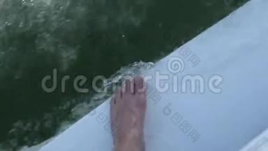 一波水，一个人的脚在一条小溪的水上，在一条小船上，泡沫在水上