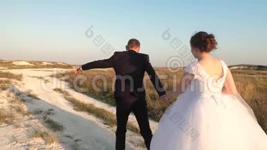 可爱的一对夫妇牵着手沿着马路跑。 新郎新娘幸福的家庭观念.. 新婚夫妇的婚礼冒险。 新娘新娘