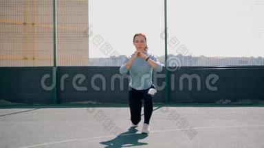 那个女孩在街道上的一个围栏地区参加体育活动。 街头健身操.. <strong>向前冲</strong>。