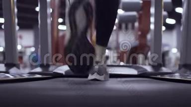 在健身房<strong>跑步</strong>机上运动的女人的<strong>运动鞋</strong>上观看