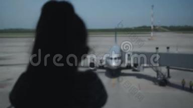 机场窗口一个孤独的小女孩的剪影..