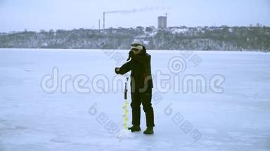 冬天，一个渔夫在城里用冰<strong>钻钻洞</strong>