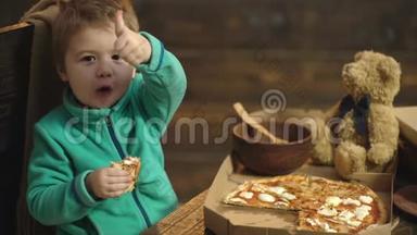 把吃披萨的可爱小男孩关起来。 男孩吃美味的披萨。 木制背景的美味意大利披萨。