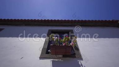 一间西班牙老房子的墙上挂着鲜花的窗户。 欧洲建筑外观