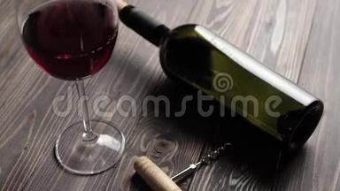 豪华红酒。 两个酒杯，开瓶器和一瓶红酒，由桌上美味的红葡萄制成。 摄像机移动