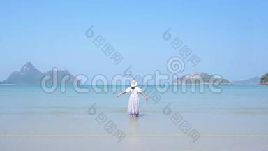 亚洲女士在美丽的海滩上变得清爽。 蓝色的水晶海。 慢动作。