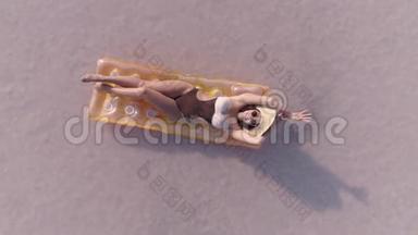 戴太阳镜的年轻女子躺在<strong>气垫</strong>上打日光浴。 女孩在阳光明媚的粉红色湖里游泳。 从上面看。