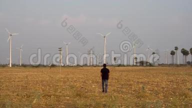 人在风电场为一家风车公司工作，走向风电厂进行检查.. 4k