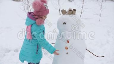 小女孩装饰雪人。 冬季运动会。