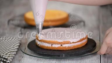 那个女人`手把奶油捏在蛋糕上。 蛋糕上的美味奶油。
