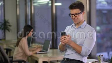 年轻人在办公室时在智能手机上使用智能家居应用程序，现代技术