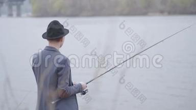 一位年轻的渔夫穿着一件<strong>夹克</strong>，戴着一顶帽檐，一位年轻的渔夫穿着一件<strong>夹克</strong>，戴着一顶帽檐