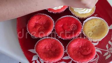 准备蛋糕红丝绒的女人。 用糕点袋涂抹奶油。 成品蛋糕在盘子里。 特写镜头。
