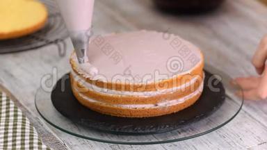 那个女人`手把奶油捏在蛋糕上。 蛋糕上的美味奶油。
