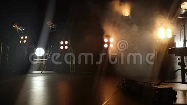 音乐会舞台的特写视频和上面的照明装置。 烟雾中的烟雾轻轻地打破了黄光和乳晕
