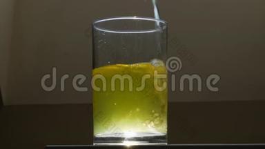 黄色的柠檬水倒在玻璃杯里。 女人或女人手拿一杯柠檬水。 关闭视野。