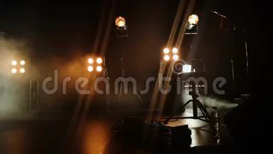 音乐会舞台的特写视频和上面的照明装置。 烟雾中的烟雾轻轻地打破了黄光和乳晕