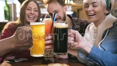 五个快乐的朋友在酒吧、酒吧和酒吧里喝着啤酒和鸡尾酒碰杯。