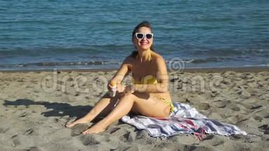 在沙滩上涂抹防晒霜的女人