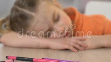 女孩睡在<strong>幼儿园</strong>的桌子上，上了一堂累人的<strong>美术</strong>课后，筋疲力尽，很亲密