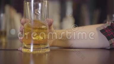 一杯淡啤酒慢悠悠地滑在桌子上，落入一个女孩特写的手中.. 在酒吧休闲。 慢慢