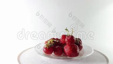 360度，视频红色草莓与叶子在一个旋转的桌子上。 360°转弯。 保健食品。 美味和维生素。