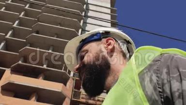 在建房屋背景下，施工领班留胡子，留胡子，戴安全帽.. 4k