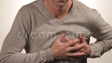 男子双手抱胸，有心脏病发作或疼痛痉挛，压在胸部，白色b上有痛苦的表情