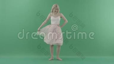 漂亮的金发女人，穿着白色衣服，在绿色背景<strong>下摆</strong>姿势