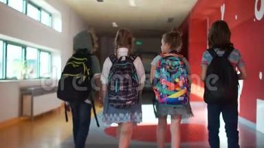 友好的青少年陪伴在学校里，沿着大厅向班级，后视。 两个女孩和两个男孩