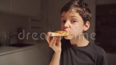 男孩深夜在家厨房吃披萨。 一个人在家。