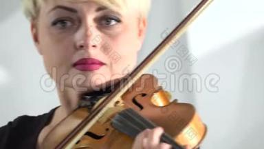 女人拿着小提琴在琴弦上鞠躬。 快关门。 白色背景