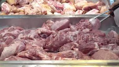展示肉制品.. 女士`用不锈钢手柄选择超市里的生猪肉