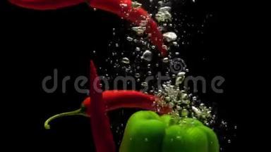 红辣椒和绿皮红辣椒在黑色的背景下<strong>落入水中</strong>