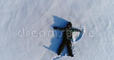 七岁<strong>的</strong>男孩穿着蓝色夹克做<strong>雪天</strong>使，空中镜头。