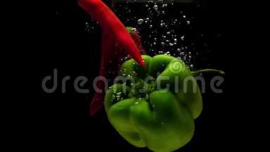 红辣椒和绿皮红辣椒在黑色的背景下<strong>落入水中</strong>