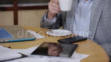 年轻人一边坐在椅子上一边喝咖啡，一边用笔记本电脑<strong>上网聊天</strong>
