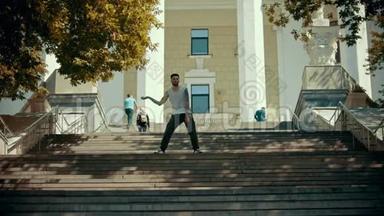 年轻时尚的男子在楼梯上跳舞，背景是一栋建筑