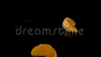 鲜橙柑桔的鱼在黑色的背景上缓慢地<strong>落入水中</strong>。