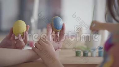 不认识的小女孩用小刷子把一颗心贴在复活节彩蛋上。 复活节的准备工作
