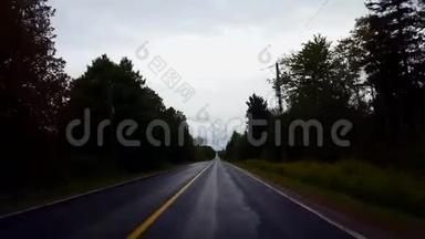 在白天驾驶农村潮湿的道路俯瞰多云的天空。 雨水暗雨后的POV驾驶点