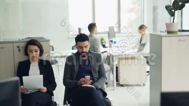 压力过大的应聘者在办公室等待面试，在女经理的时候阅读简历，使用智能手机