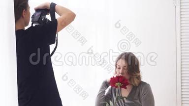 专业摄影棚摄影师特写，手里拿着大红花拍模特。 媒体